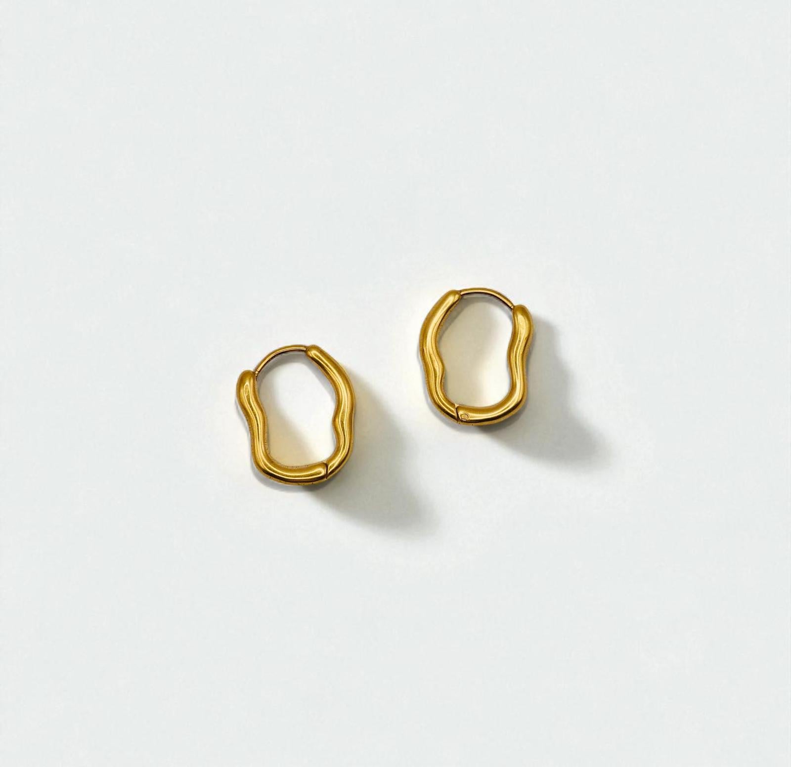 Pair of gold hoop earrings on a light gray background