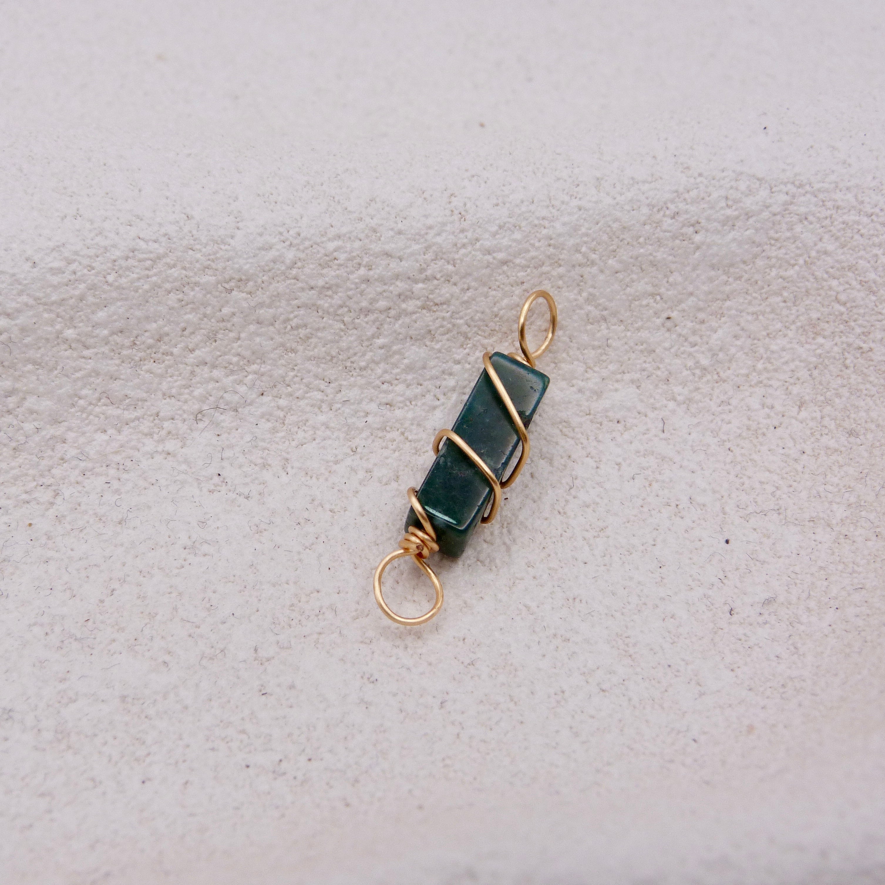 Jewelry pendant with dark green stone and gold wire