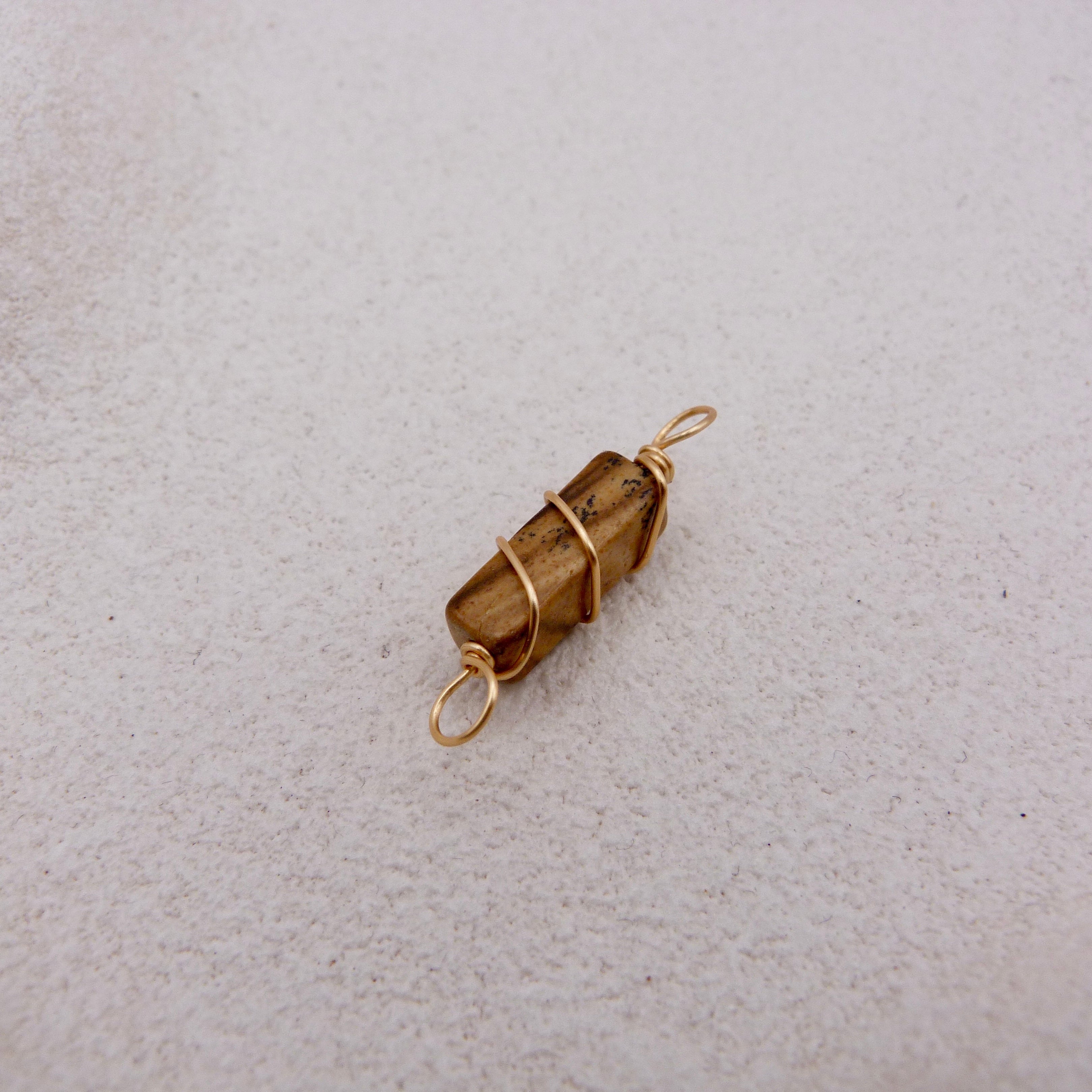 Brown stone wrapped in gold wire 