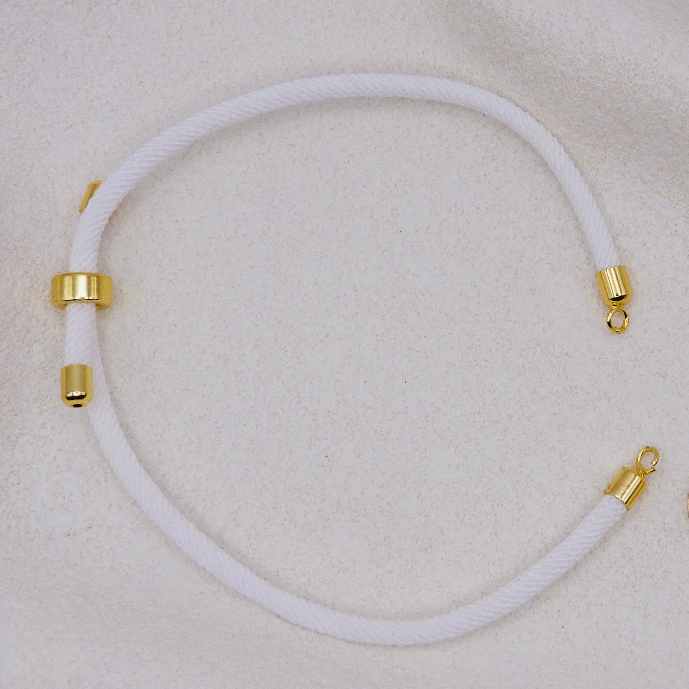 White rope necklace with gold clasps. The bracelet has a gap to cutomise.
