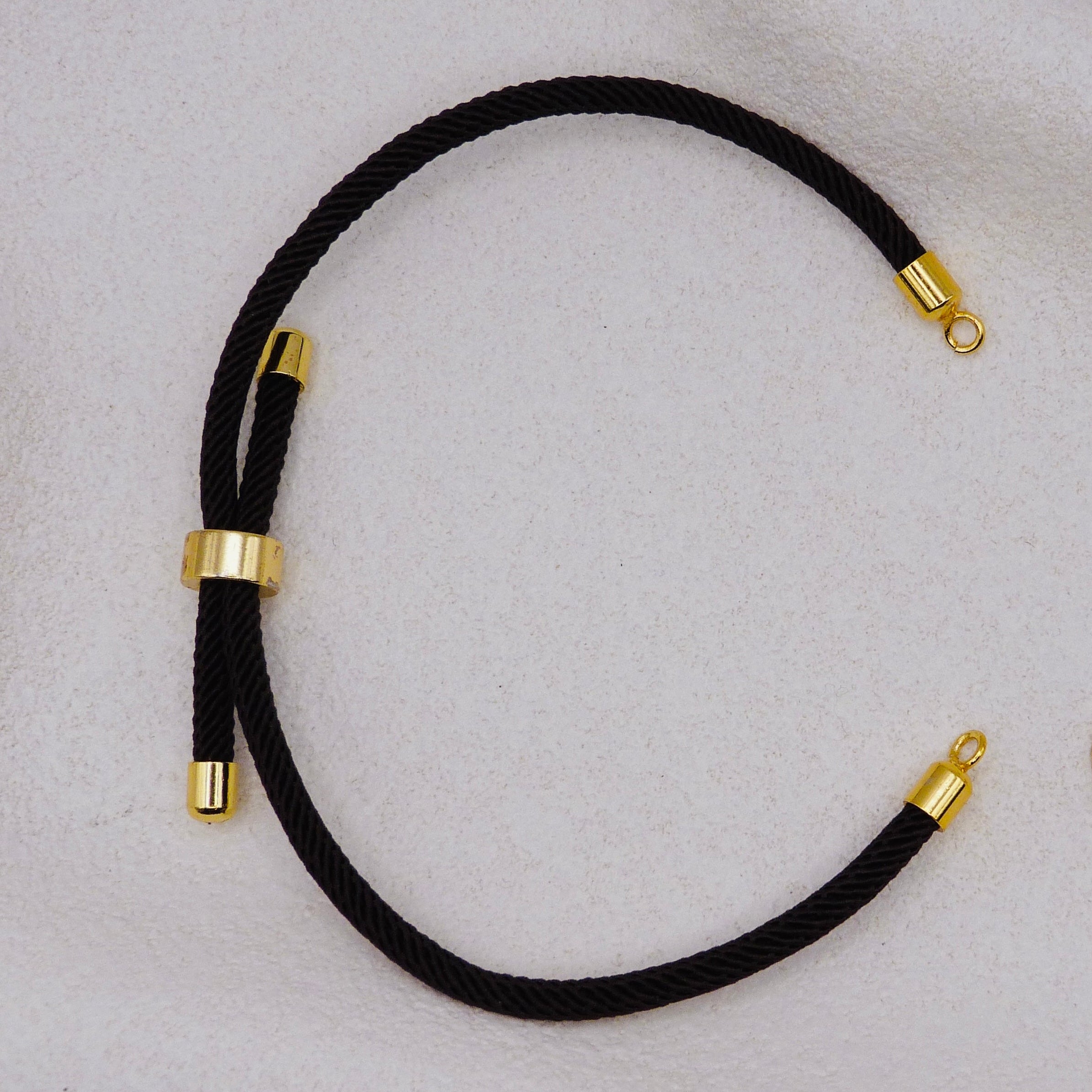 Black rope necklace with gold clasps. The bracelet has a gap to cutomise.