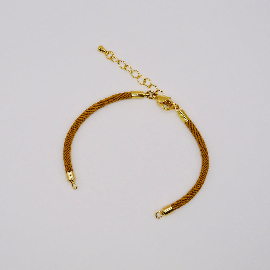Gold bracelet on a light gray background