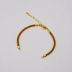 Gold bracelet on a light gray background