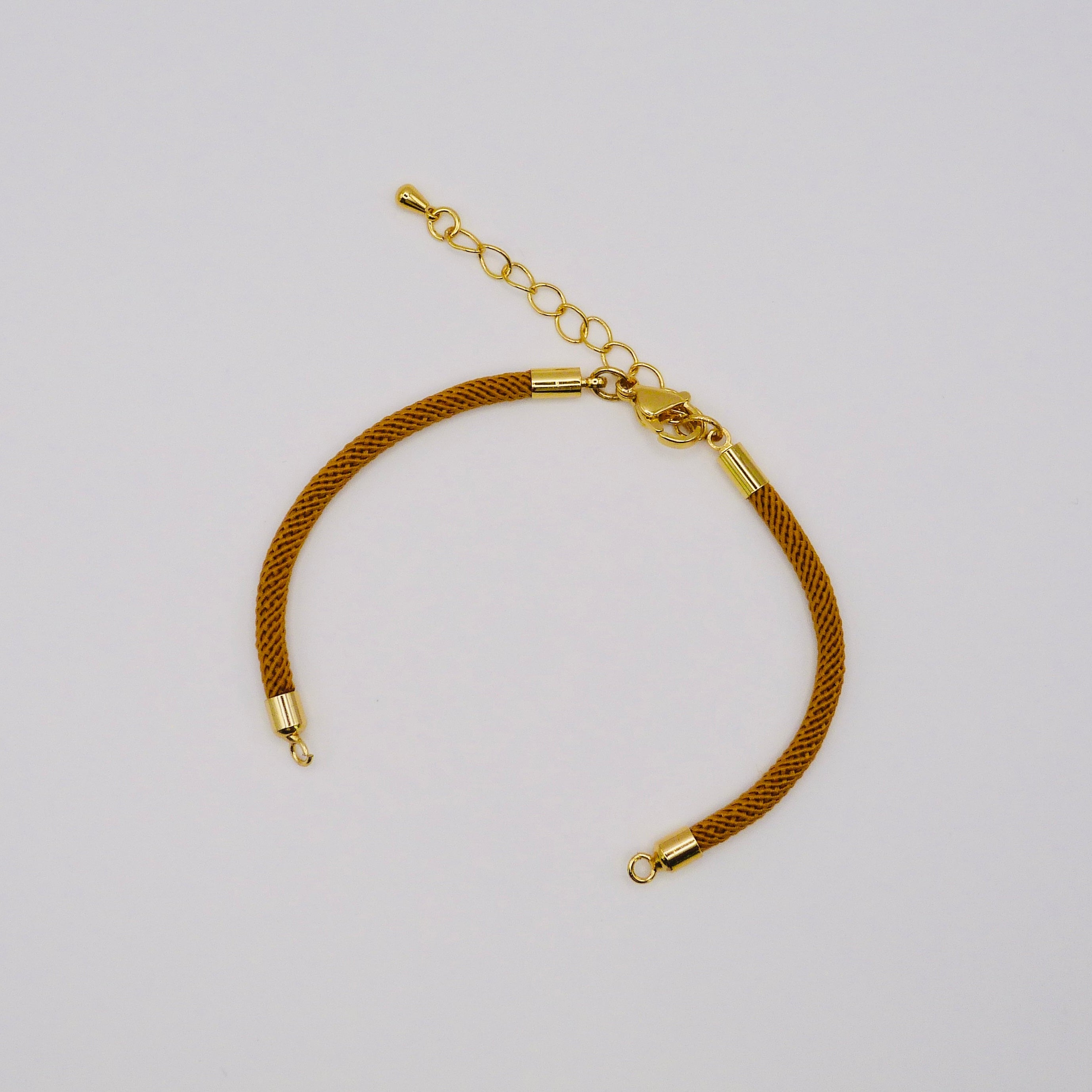 Gold bracelet on a light gray background
