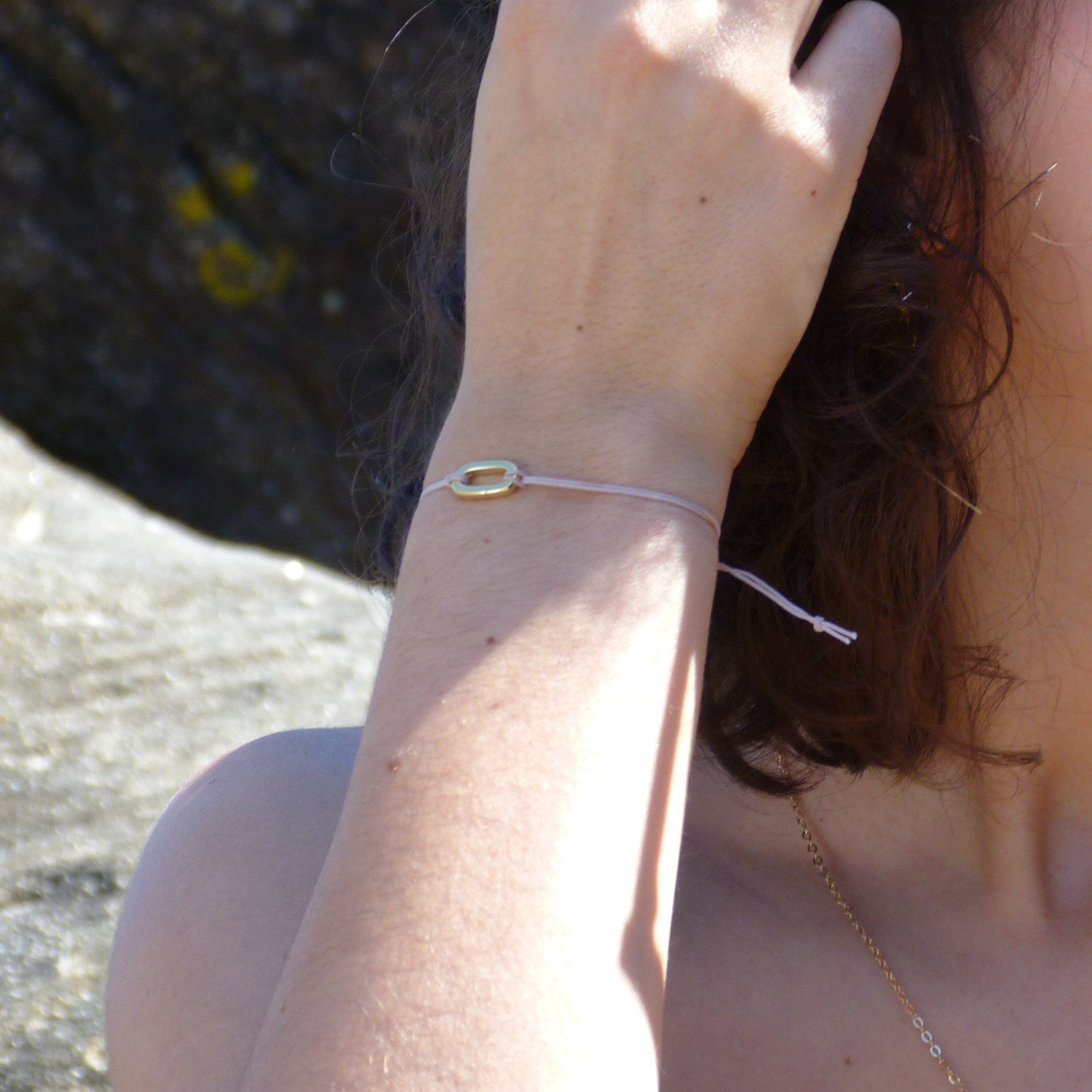Waterproof Link charm on a thin thread bracelet.