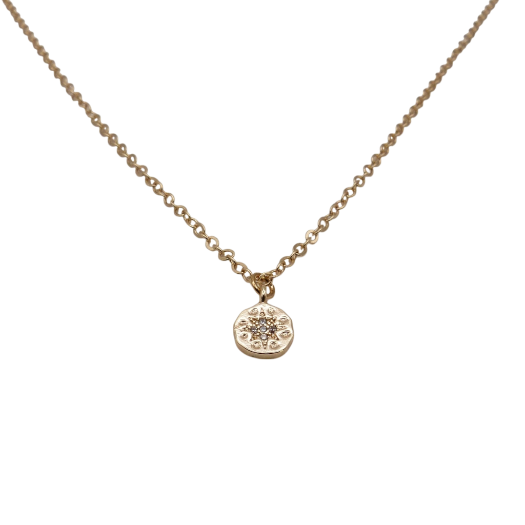 Gold chain necklace with a small round zirconia pendant.