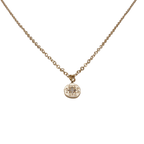 Gold chain necklace with a small round zirconia pendant.