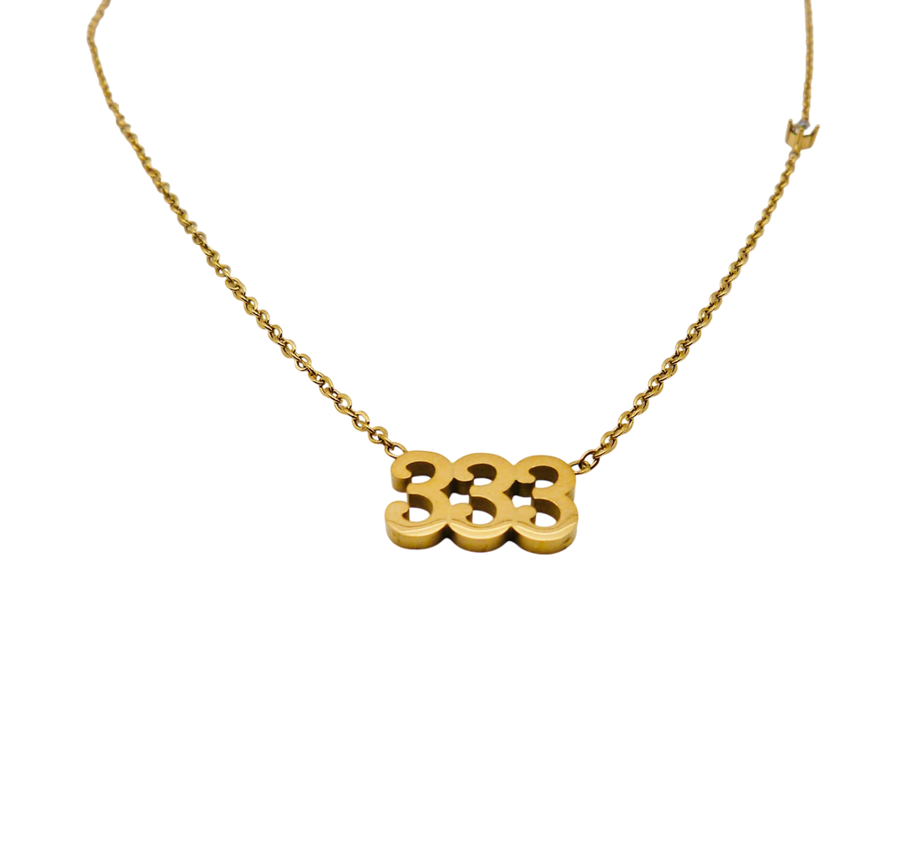 Gold necklace with the number '333' and small stone in stainless steel.