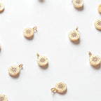 Gold zirconia charm with diamond-like stones.