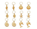 Collection of gold bikini charms with various sea-themed designs on a white background